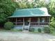 Log home with a covered porch and a green roof at 207 High House Rd, Cary, NC 27513