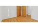 Bright bedroom features hardwood floors and closet with wooden doors at 209 High House Rd, Cary, NC 27513