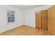 Bright bedroom features hardwood floors, a window overlooking a wooded area, and closet with wooden doors at 209 High House Rd, Cary, NC 27513