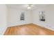 Bedroom featuring hardwood floors, two windows, and neutral paint at 209 High House Rd, Cary, NC 27513