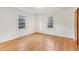Bedroom featuring hardwood floors, two windows, and neutral paint at 209 High House Rd, Cary, NC 27513
