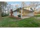 Back of home and carport showing brick accents, white siding, and spacious backyard at 209 High House Rd, Cary, NC 27513