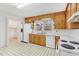 Cozy kitchen featuring wood cabinets, white appliances, and a window view at 209 High House Rd, Cary, NC 27513