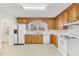 Functional kitchen with wooden cabinets, white appliances, and a window over the sink at 209 High House Rd, Cary, NC 27513