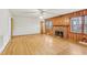 Spacious living room with a brick fireplace, wood paneled walls, hardwood floors, and ample natural light at 209 High House Rd, Cary, NC 27513