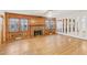 Cozy living room featuring hardwood floors, a brick fireplace, wood-paneled walls, and large windows at 209 High House Rd, Cary, NC 27513