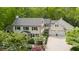 Aerial view of a luxury home with a manicured lawn and large driveway surrounded by lush trees at 2105 White Oak Rd, Raleigh, NC 27608