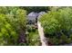 Aerial view of a stately home surrounded by lush trees, a manicured lawn, and a long driveway at 2105 White Oak Rd, Raleigh, NC 27608