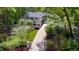 Aerial view of a brick home with lush greenery, manicured lawns, and a long driveway at 2105 White Oak Rd, Raleigh, NC 27608
