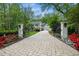A long cobblestone driveway leads to this grand home with black shutters and manicured landscaping at 2105 White Oak Rd, Raleigh, NC 27608