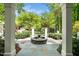 View from the portico showcases a stone fountain, iron gate, and lush landscaping at 2105 White Oak Rd, Raleigh, NC 27608