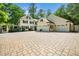 Stunning home featuring a spacious three-car garage and a charming brick-paved driveway, surrounded by lush landscaping at 2105 White Oak Rd, Raleigh, NC 27608