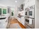Modern kitchen with stainless steel appliances, white cabinetry, and hardwood floors at 2105 White Oak Rd, Raleigh, NC 27608