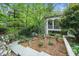 Charming two-story home featuring beautifully landscaped yard with mature trees, stone pathway, and inviting curb appeal at 2105 White Oak Rd, Raleigh, NC 27608