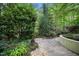 Lush landscaped garden featuring a stone walkway, mature trees, and vibrant greenery, creating a serene outdoor oasis at 2105 White Oak Rd, Raleigh, NC 27608
