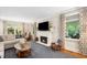 Cozy living room featuring a fireplace, large windows, and comfortable seating arrangements at 2105 White Oak Rd, Raleigh, NC 27608
