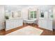 Bright bathroom featuring dual sinks, free standing tub, large mirrors, and wood floors at 2105 White Oak Rd, Raleigh, NC 27608