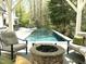 Outdoor patio featuring an in-ground pool, modern seating and a stone fire pit at 2105 White Oak Rd, Raleigh, NC 27608