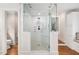 Modern walk-in shower with glass doors, multiple shower heads, and tiled walls and floor at 2105 White Oak Rd, Raleigh, NC 27608