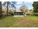 Expansive backyard with a view of the screened porch, green lawn, and mature trees at 2106 Ruffin St, Durham, NC 27704
