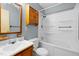 A clean bathroom featuring a shower-tub combo, wood vanity and blue walls at 2106 Ruffin St, Durham, NC 27704