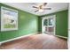 A bright bedroom featuring hardwood floors, green walls, a ceiling fan, and a sliding glass door at 2106 Ruffin St, Durham, NC 27704