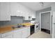 The kitchen features white cabinets, gray walls, wood counters, and black appliances at 2106 Ruffin St, Durham, NC 27704