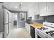 Kitchen featuring white cabinets, gray walls, wood counters, an electric range, and black appliances at 2106 Ruffin St, Durham, NC 27704