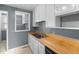 Kitchen with wood counters, gray walls, white cabinets, an electric range, and a stainless steel sink at 2106 Ruffin St, Durham, NC 27704