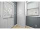The mud room includes a door to the outside, a window, a wall cabinet, and a beige tile floor at 2106 Ruffin St, Durham, NC 27704