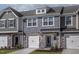 Charming townhome showcasing stone accents, individual garages, and appealing curb appeal with manicured landscaping at 2112 Willow Gln Dr, Graham, NC 27253