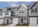 Charming townhome featuring a stone and shingle facade, attached garages, and neatly landscaped front yards at 2118 Willow Gln Dr, Graham, NC 27253