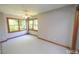 Bright bedroom featuring neutral walls, wood trim, plush carpet, and large windows at 212 Columbia W Pl, Chapel Hill, NC 27516