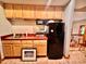 Charming kitchenette with wooden cabinets, red countertops, and a black refrigerator at 212 Columbia W Pl, Chapel Hill, NC 27516