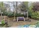 The backyard features a seating area, colorful decor, and mature landscaping at 2225 Whistling Straits Way, Raleigh, NC 27604