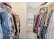 Spacious walk-in closet offers ample storage with clothes and window for natural light at 2225 Whistling Straits Way, Raleigh, NC 27604