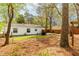 Large, treed backyard with wooden deck, storage, and privacy at 2400 Perennial St, Raleigh, NC 27603