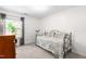 Cozy bedroom with carpet and an outdoor view features a daybed, a dresser, and natural light at 2400 Perennial St, Raleigh, NC 27603