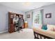 Comfortable blue bedroom boasts a desk, chair, and sofa for work and relaxation at 2400 Perennial St, Raleigh, NC 27603