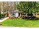 Well-manicured front yard with a lovely lawn, mature trees, and charming details at 2400 Perennial St, Raleigh, NC 27603