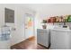 Practical laundry room equipped with a washer, dryer, and shelving for storage and backyard access at 2400 Perennial St, Raleigh, NC 27603