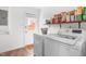 Bright laundry room featuring modern appliances, a wood shelf, and access to the outdoors at 2400 Perennial St, Raleigh, NC 27603