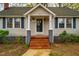 A welcoming front entrance with brick steps, classic white columns, and a decorative wreath on the glass front door at 2422 S Alston Ave, Durham, NC 27713