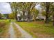 A charming single-story home with a sprawling front yard, mature trees, and a gravel driveway at 2422 S Alston Ave, Durham, NC 27713