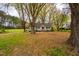 A charming single-story home with a sprawling front yard, mature trees, and a gravel driveway at 2422 S Alston Ave, Durham, NC 27713