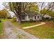A charming single-story home with a gravel driveway, mature trees, and a well-maintained front yard at 2422 S Alston Ave, Durham, NC 27713