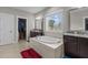 Bright bathroom with a large tub, dual vanities, and a walk-in closet at 2713 Tunstall Grove Dr, Apex, NC 27523