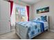 Cozy bedroom featuring a rustic-style bed, bright window with colorful curtains, and neutral walls at 2713 Tunstall Grove Dr, Apex, NC 27523