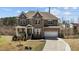 Charming two-story home boasts a stone and brick facade, attached two car garage, and a well-manicured front yard at 2713 Tunstall Grove Dr, Apex, NC 27523