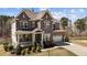 Beautiful two-story home featuring a stone and brick facade and a well-manicured front yard at 2713 Tunstall Grove Dr, Apex, NC 27523